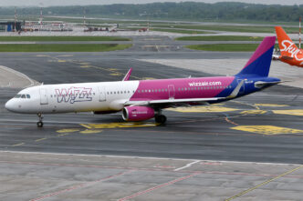 Airbus A321 v purpurovo-bílých barvách Wizz Air pojíždí po letištní ploše.
