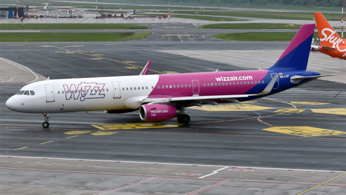 Airbus A321 v purpurovo-bílých barvách Wizz Air pojíždí po letištní ploše.