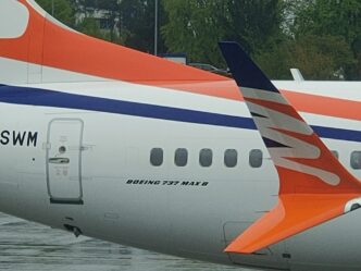 Detail zadní části trupu a ocasní plochy Boeingu 737 MAX 8 s oranžovo-modrým znakem Smartwings.